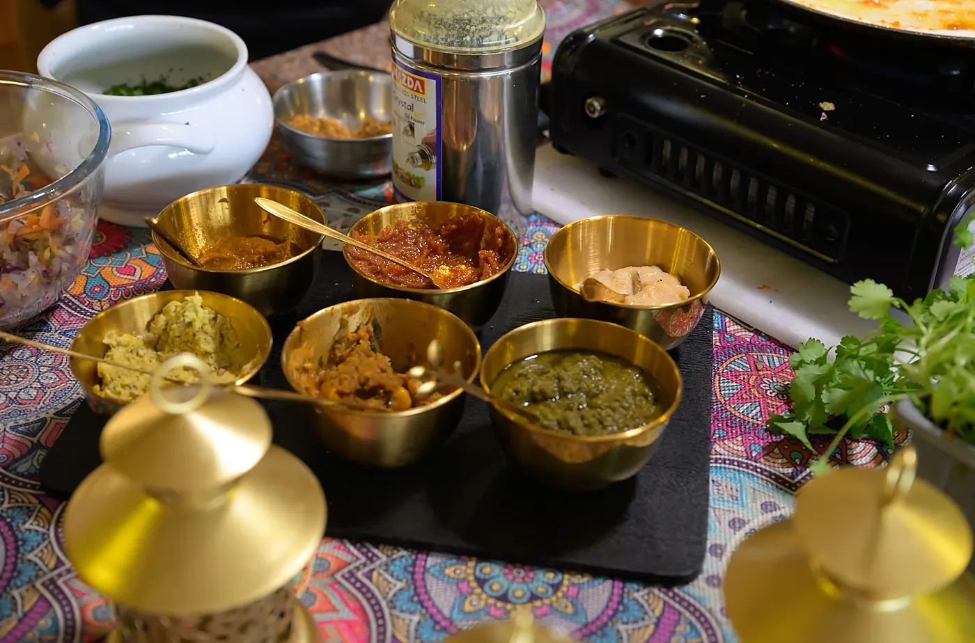Spices and chutneys in brass pots on the counter