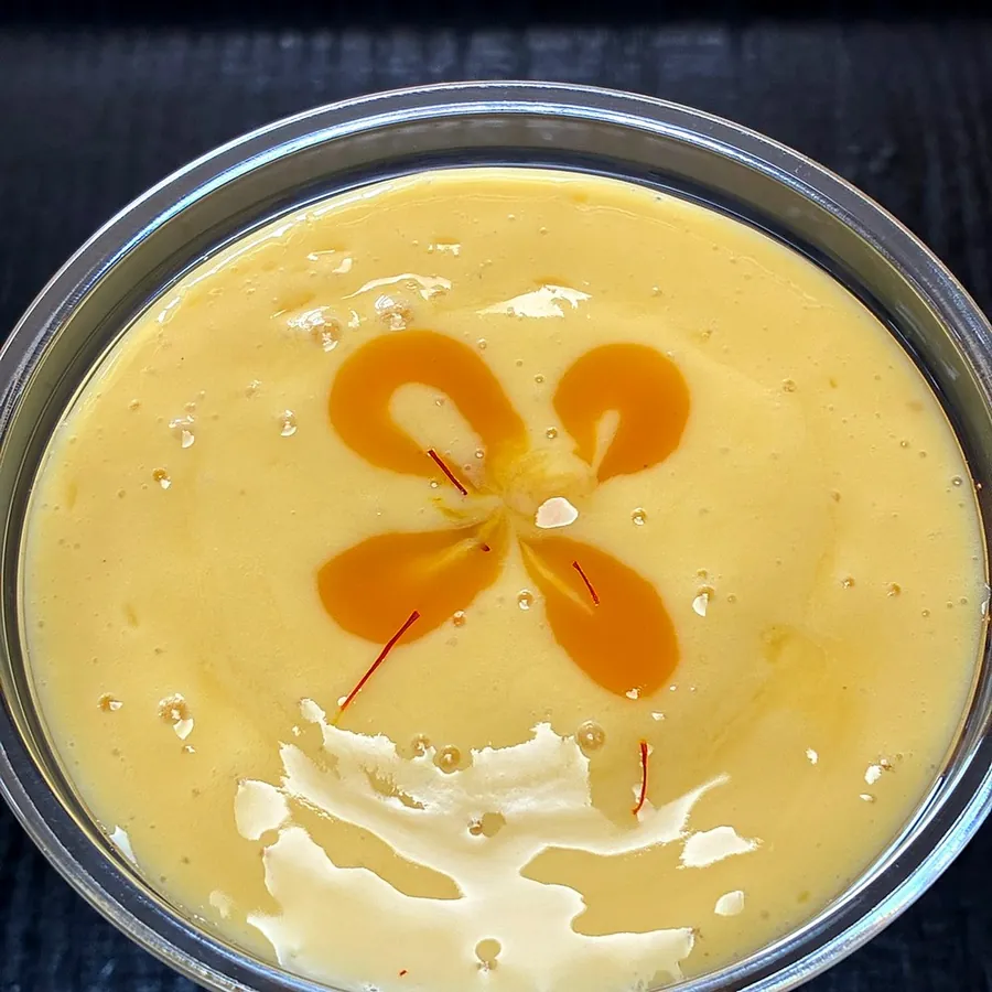 Saffron mango lassi from above with a saffron swirl